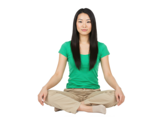 Serene young woman sitting cross-legged in a meditative pose, wearing a green top and beige pants, isolated on white background