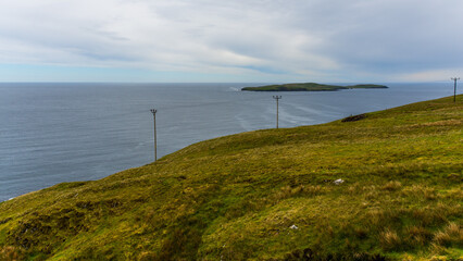 the coast of Shetland Islands with the small island of Mousa in the distance