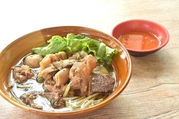 boiled braised beef meat and tendon couple organ in herb brown soup on bowl dipping spicy chili sauce 