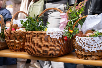 Easter basket for blessing in a church. Traditional woven wicker Paschal basket or Kosz wielkanocny filled with various food, ready to be blessed by a priest as part of the Easter tradition.