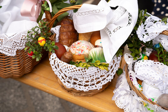 Easter basket for blessing in a church. Traditional woven wicker Paschal basket or Kosz wielkanocny filled with various food, ready to be blessed by a priest as part of the Easter tradition.