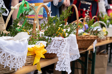 Easter basket for blessing in a church. Traditional woven wicker Paschal basket or Kosz wielkanocny filled with various food, ready to be blessed by a priest as part of the Easter tradition. © Longfin Media