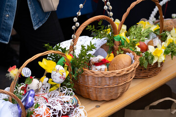 Easter basket for blessing in a church. Traditional woven wicker Paschal basket or Kosz wielkanocny filled with various food, ready to be blessed by a priest as part of the Easter tradition.
