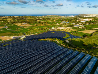 Drone view of solar farm in Europe, sun quarry, solar panels, sun panels.  Malta island, green hills, countryside