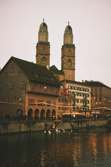 Zurich, Switzerland, Munsterbrucke bridge, Fraumunster, Grossmunster, Limmat river at dusk during Christmas