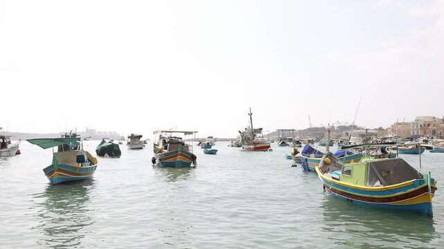 Colorful maltese luzzu boats moored near Marsaxlokk fishers village on Malta