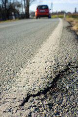 Cracks in a road asphalt due to frost in winter vertical