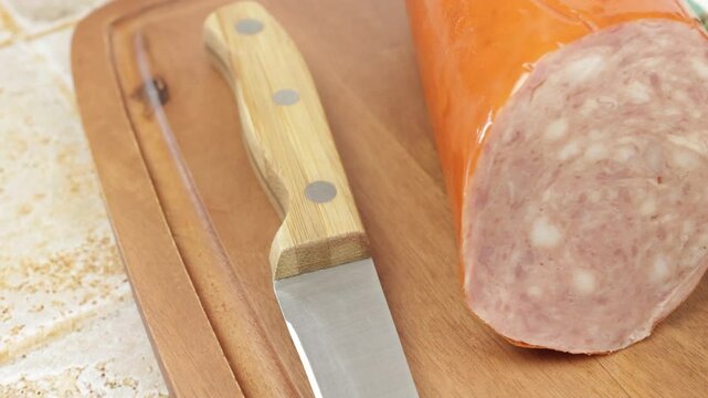 saucisson &agrave; l'ail, en gros plan, sur une planche &agrave; d&eacute;couper