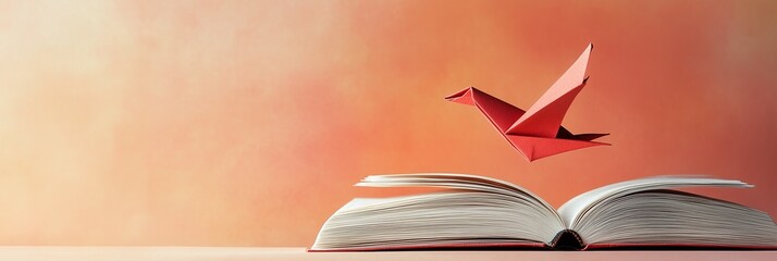 A paper bird emerging from an open book on a pastel gradient background with soft pink and turquoise tones