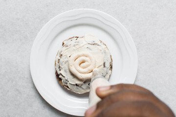 Overhead view of vanilla cookies being frosted, top view of cookies with a vanilla cream frosting, process of frosting cookies