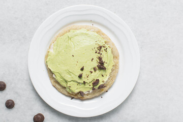 Overhead view of Large homemade mint and chocolate chip cookies on a white plate, top view of bakery style mint and chocolate chip cookies
