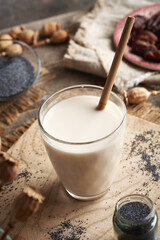 Vegan poppy seed milk in a glass cup with ecological bamboo straw