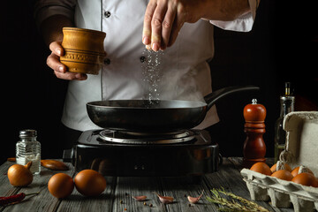 A skilled chef prepares a meal in a cozy kitchen, delicately adding salt to a sizzling pan filled...