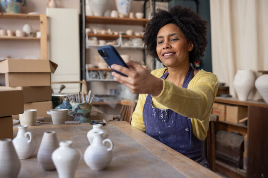 Craft Business Owner taking photos of her pottery to sell online