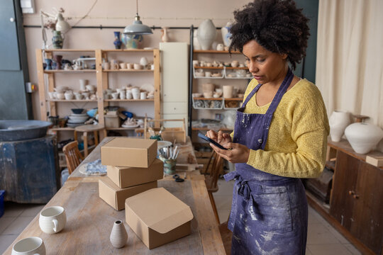 Craft business owner checking online orders using her phone