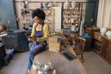 Craft business owner using her phone for online banking