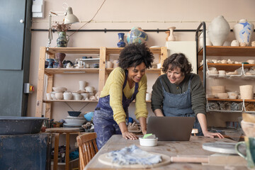 Two women starting a craft business looking at a laptop computer