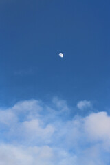Half Moon Above Clouds on a Blue Sky