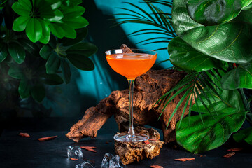 Orange alcoholic cocktail drink with bourbon, bitters, prosecco and lemon juice. Dark blue...