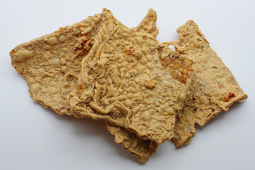 Keripik Tempe or Tempe chips, a typical Indonesian food made from thinly sliced ​​tempeh and then fried using seasoned flour. It's salty and savory. Close up and selective focus image.