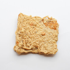 Keripik Tempe or Tempe chips, a typical Indonesian food made from thinly sliced ​​tempeh and then fried using seasoned flour. It's salty and savory. Close up and selective focus image.