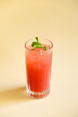 Raspberry lemonade with a branch of mint on a beige background