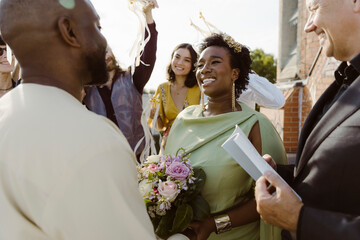 Happy newly married couple looking at each other while exchanging vows at ceremony