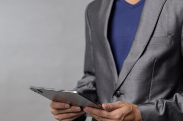 Professional Man in Suit Holding Tablet with Gray Background