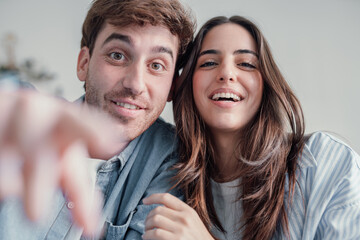 Happy cheerful couple choosing and clicking putting finger on the camera shopping online internet....