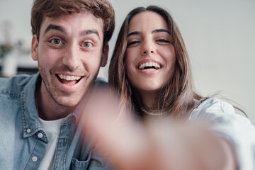 Happy cheerful couple choosing and clicking putting finger on the camera shopping online internet. Euphoric having fun surfing the net caucasian people enjoying technology touching screen..
