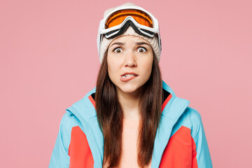 Close up skier young sad shocked woman she wear warm blue padded jacket ski goggles mask spend extreme weekend winter season in mountains look camera isolated on plain pink background. Hobby concept.