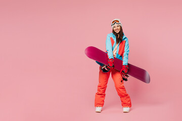 Full body side view young cheerful woman wear warm blue padded jacket ski goggles mask spend...