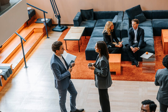 High angle view of female entrepreneur discussing with businessman during networking event at convention center