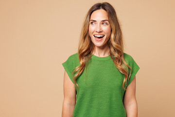 Young shocked surprised excited amazed happy woman she wear green t-shirt casual clothes look aside...