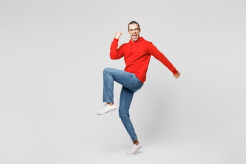 Full body young middle eastern man wear red hoody casual clothes doing winner gesture celebrate...