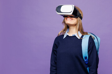 Young cheerful fun girl student wear blue casual clothes glasses backpack bag watching in vr headset pc gadget isolated on plain pastel light purple background. High school university college concept.