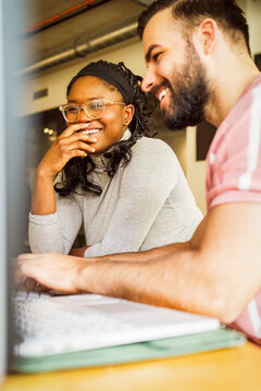 Low angle view of happy male and female IT professional at tech startup office