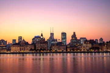 Naklejka premium Sunset of Shanghai city modern skyscraper night light cityscape in twilight golden sky of Historical architecture on the bund of Shanghai with reflection of buildings in city Shanghai, China
