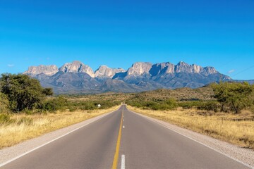 Fototapeta premium Scenic highway leading to sierra del carmen mountains under clear blue sky