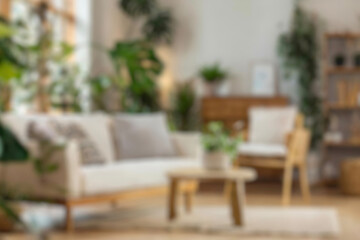 Blurred view of modern living room with sofa and soft bench. room interior with couch, armchair and coffee table or shelving units. stylish living room. comfortable workplace near big window.