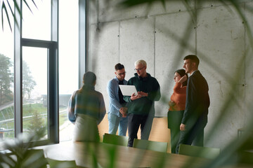 A diverse multiethnic business team engages in a collaborative meeting, discussing strategies and...