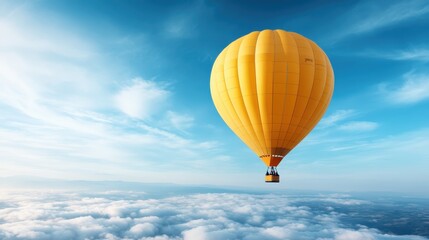 Naklejka premium A vibrant yellow hot air balloon floats gracefully above fluffy white clouds under a clear blue sky, capturing a sense of freedom and adventure in the vastness of the atmosphere.