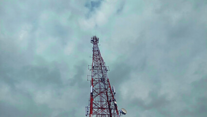 A radio transmitter tower standing under a dramatic overcast sky.