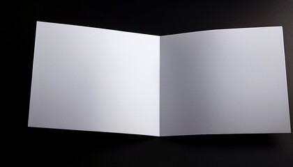 blank white sheet of paper folded in half isolated on black background