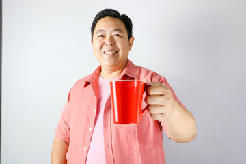 A man holding a red cup for coffee or tea