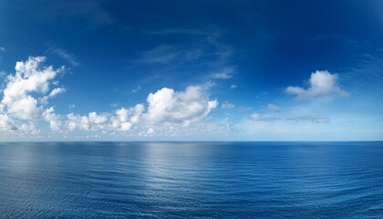 Obraz premium a sunny day with blue sky white clouds and a peaceful ocean