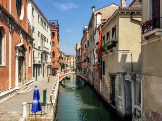 Fototapeta premium A Quiet Corner of Venice. A narrow canal winds its way through the city, lined with colorful buildings and picturesque bridges.