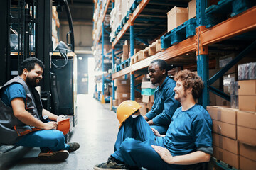 Warehouse workers taking a break sitting near forklift in storage facility