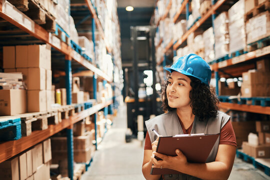 Female warehouse worker inspecting inventory with clipboard