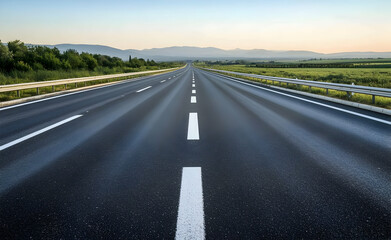 Asphalt Highway Leading to Distant Mountains at Sunrise
